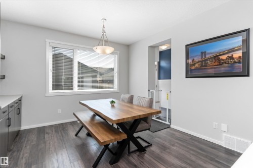 Dining area featuring wood-finish flooring, a window with blinds, and a contemporary pendant light fixture - 3456 Cutler Crescent Sw, Edmonton, AB - Indoor Photo Showing Dining Room