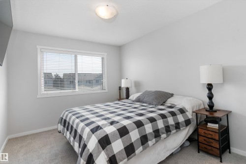 Carpeted bedroom featuring a window with blinds, white trim, and a flush-mount ceiling light - 3456 Cutler Crescent Sw, Edmonton, AB - Indoor Photo Showing Bedroom