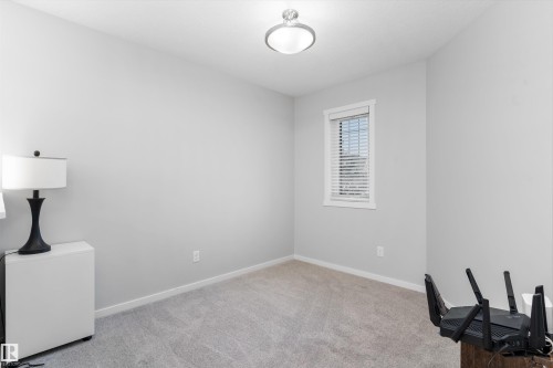 Neutral gray walls with white trim, gray carpeting, a single window with blinds, and a flush-mount ceiling light fixture - 3456 Cutler Crescent Sw, Edmonton, AB - Indoor Photo Showing Other Room