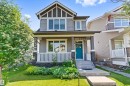 Two-story residence featuring a covered front porch with white railing, stone accents on columns and foundation, a vibrant turquoise entry door with glass inserts, and a concrete pathway - 3456 Cutler Crescent Sw, Edmonton, AB  - Outdoor With Deck Patio Veranda With Facade 