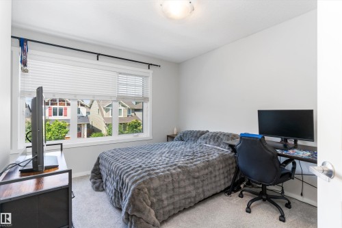 Bright bedroom featuring a large window with white blinds, light gray wall paint, and gray carpeting - 3456 Cutler Crescent Sw, Edmonton, AB - Indoor Photo Showing Bedroom