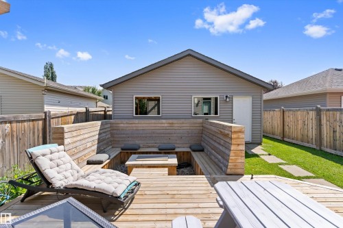 Expansive wooden deck featuring built-in bench seating and a fire pit - 3456 Cutler Crescent Sw, Edmonton, AB - Outdoor With Deck Patio Veranda With Exterior