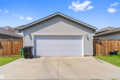 Attached two-car garage with a panel-style door, exterior siding, and a gabled roofline - 3456 Cutler Crescent Sw, Edmonton, AB - Outdoor