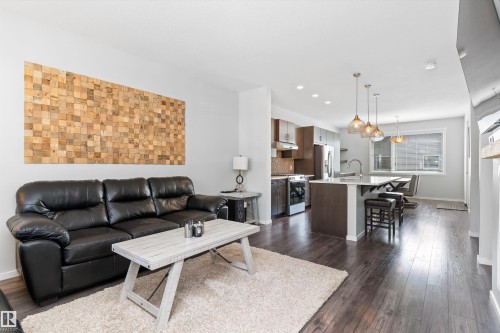 Open-concept living area featuring dark wood-finish flooring, white walls, and recessed lighting - 3456 Cutler Crescent Sw, Edmonton, AB - Indoor Photo Showing Living Room