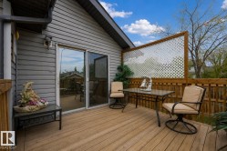 Exterior wood deck featuring a lattice privacy screen and direct access to interior spaces via sliding glass doors - 