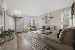 Living area featuring wood-finish flooring, a large bay window, and a contemporary ceiling light fixture - 