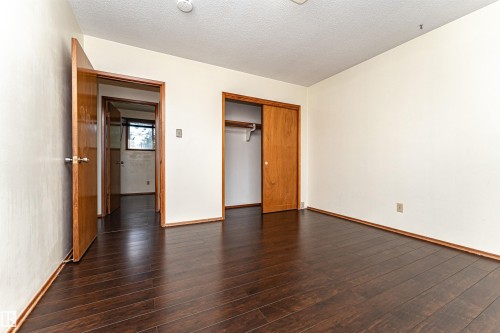 Room featuring dark wood-finish flooring, light-toned walls, and wood trim throughout - 4812 105B Street Nw, Edmonton, AB - Indoor Photo Showing Other Room