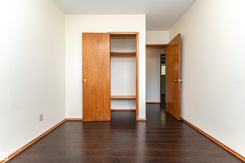 Room featuring dark wood-finish flooring, white walls, and wood trim - 4812 105B Street Nw, Edmonton, AB - Indoor Photo Showing Other Room