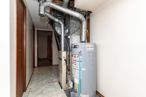 Utility area featuring a water heater and furnace with exposed ductwork - 4812 105B Street Nw, Edmonton, AB - Indoor Photo Showing Basement