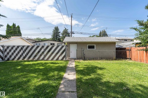 Expansive green lawn with a concrete pathway leading to a detached structure - 4812 105B Street Nw, Edmonton, AB - Outdoor