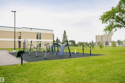 Outdoor fitness equipment on a rubberized surface, surrounded by expansive green lawn - 4812 105B Street Nw, Edmonton, AB - Outdoor