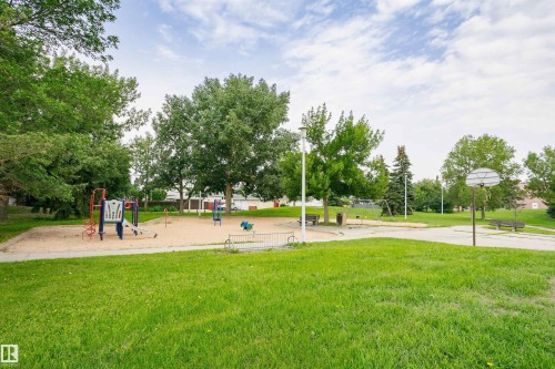 Expansive green space featuring playground equipment, a basketball court, and mature trees - 4812 105B Street Nw, Edmonton, AB - Outdoor