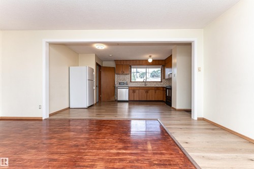 Kitchen with wood-finish cabinetry, a window over the sink, and a tiled backsplash - 4812 105B Street Nw, Edmonton, AB - Indoor Photo Showing Other Room