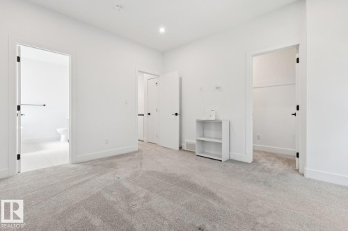 Spacious room with light-toned carpeting and bright white walls - 10531 67 Avenue Nw, Edmonton, AB - Indoor Photo Showing Other Room