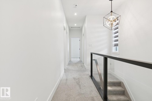 Hallway featuring light gray carpeting, recessed lighting, and a modern geometric pendant light - 10531 67 Avenue Nw, Edmonton, AB - Indoor Photo Showing Other Room