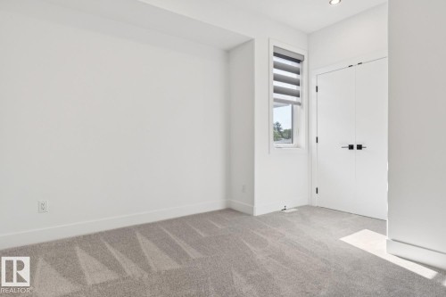 Neutral-toned carpet flooring complementing white walls and trim - 10531 67 Avenue Nw, Edmonton, AB - Indoor Photo Showing Other Room