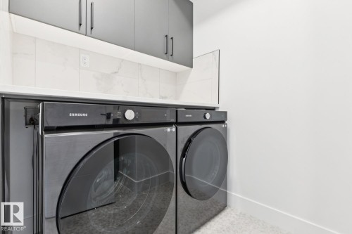 Contemporary laundry area featuring stacked appliances - 10531 67 Avenue Nw, Edmonton, AB - Indoor Photo Showing Laundry Room