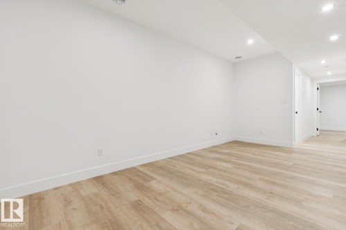 Spacious room featuring light wood-finish flooring, recessed lighting, and crisp white walls with matching baseboards - 10531 67 Avenue Nw, Edmonton, AB - Indoor Photo Showing Other Room