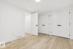 Interior room featuring light wood-finish flooring, white walls, and bright overhead lighting - 