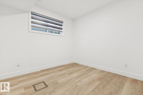 Room featuring light wood-finish flooring, white baseboards, and a window with blinds - 10531 67 Avenue Nw, Edmonton, AB - Indoor Photo Showing Other Room
