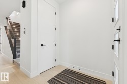 Bright entry hallway featuring light wood-finish flooring - 