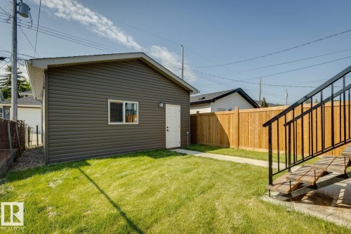 Detached garage with dark grey siding, white door, and white-framed window - 10531 67 Avenue Nw, Edmonton, AB - Outdoor With Exterior