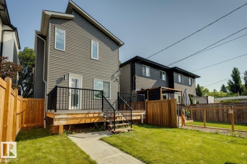 Rear exterior showcasing grey horizontal siding and white-trimmed windows - 10531 67 Avenue Nw, Edmonton, AB - Outdoor With Deck Patio Veranda