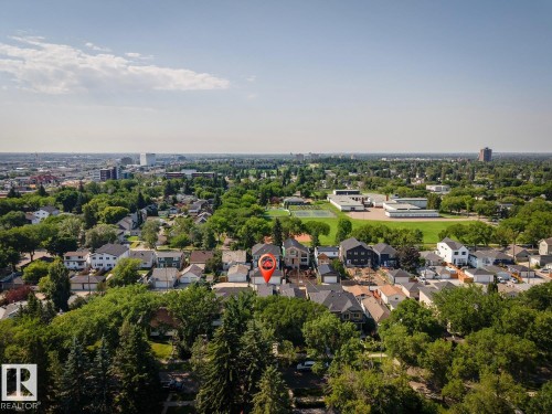 Aerial perspective showcasing a residential neighborhood with a mix of architectural styles, mature trees, and institutional buildings - 10531 67 Avenue Nw, Edmonton, AB - Outdoor With View