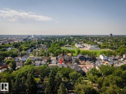 Aerial perspective showcasing a residential neighborhood with a mix of architectural styles, mature trees, and institutional buildings - 