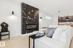 Statement fireplace featuring black and gold veined stone with an integrated linear electric fireplace - 