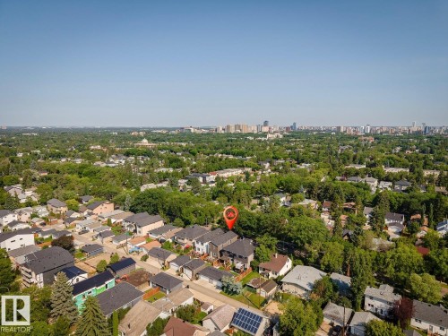 Aerial perspective showcasing a residential neighborhood with a distant cityscape - 10531 67 Avenue Nw, Edmonton, AB - Outdoor With View