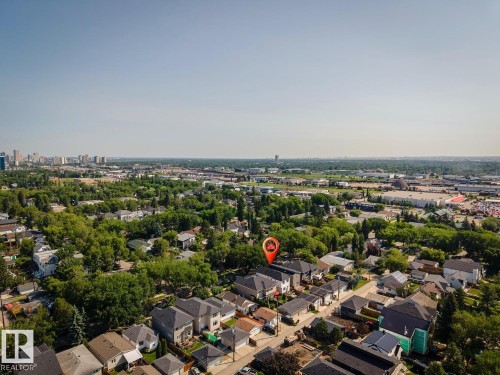 Aerial view showcasing a residential neighborhood with a distant cityscape and commercial buildings - 10531 67 Avenue Nw, Edmonton, AB - Outdoor With View