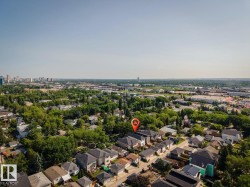 Aerial view showcasing a residential neighborhood with a distant cityscape and commercial buildings - 
