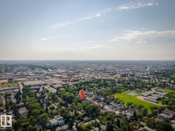 Expansive aerial perspective showcasing a residential neighborhood with mature tree canopies, green spaces, and a variety of architectural styles - 