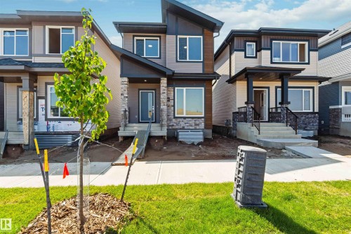 Modern two-story residence featuring a multi-textured facade with vertical siding, horizontal siding, and stone accents - 223 157 Avenue Ne, Edmonton, AB - Outdoor With Facade