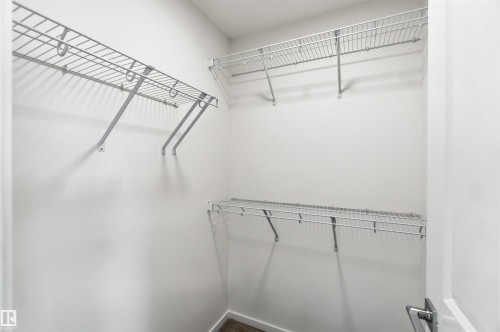 White closet interior featuring three levels of wire shelving and carpeting - 223 157 Avenue Ne, Edmonton, AB - Indoor With Storage
