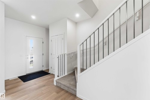 Foyer featuring light wood-finish flooring, a contemporary front door with an integrated vertical window, and recessed ceiling lighting - 223 157 Avenue Ne, Edmonton, AB - Indoor Photo Showing Other Room