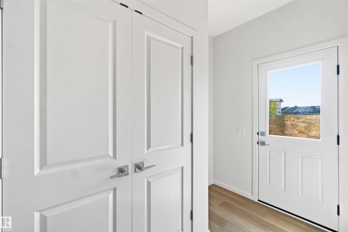 Entryway featuring wood-finish flooring and a white paneled door with integrated window - 223 157 Avenue Ne, Edmonton, AB - Indoor Photo Showing Other Room