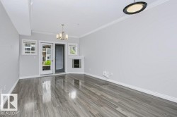 Spacious room featuring wood-finish flooring, light grey wall paint, and white trim - 