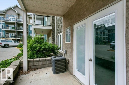 Private patio area featuring concrete paving and a retaining wall - #137 10121 80 Av Nw, Edmonton, AB - Outdoor