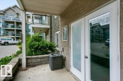 Private patio area featuring concrete paving and a retaining wall - 