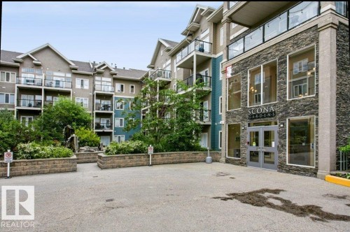 "Scona Gardens" building entrance featuring a stone facade and large window panels - #137 10121 80 Av Nw, Edmonton, AB - Outdoor With Facade