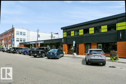 Modern commercial building with a black facade and vibrant lime green accents - #137 10121 80 Av Nw, Edmonton, AB - Outdoor