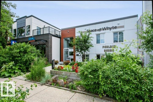 Contemporary multi-level building featuring a combination of light-colored siding, dark brick accents, and wood-finish paneling - #137 10121 80 Av Nw, Edmonton, AB - Outdoor