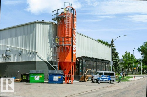 Industrial-style building featuring a prominent orange silo structure with exterior access ladders and platforms - #137 10121 80 Av Nw, Edmonton, AB - Outdoor
