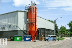 Industrial-style building featuring a prominent orange silo structure with exterior access ladders and platforms - 