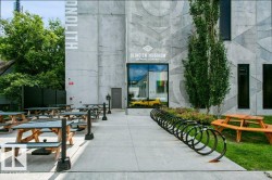 Concrete facade with geometric patterning, featuring a prominent entrance with large windows - 