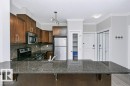 Kitchen featuring a large breakfast bar with granite-style countertop - #137 10121 80 Av Nw, Edmonton, AB  - Indoor Photo Showing Kitchen 