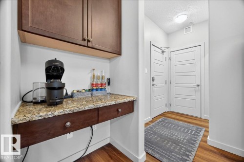 Built-in countertop with brown wood-finish cabinetry and drawers - 106 320 Ambleside Link Sw, Edmonton, AB - Indoor Photo Showing Other Room