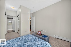Carpeted bedroom featuring light gray walls and a ceiling light fixture - 